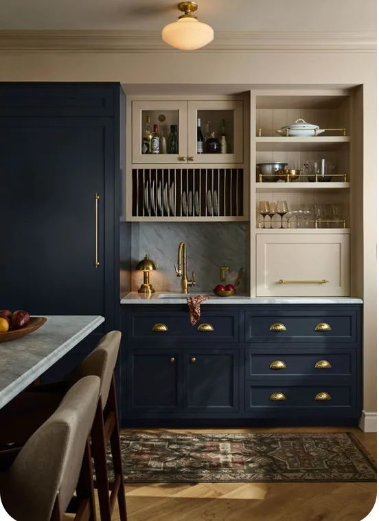 Navy cabinets with brass pulls and an open plate rack